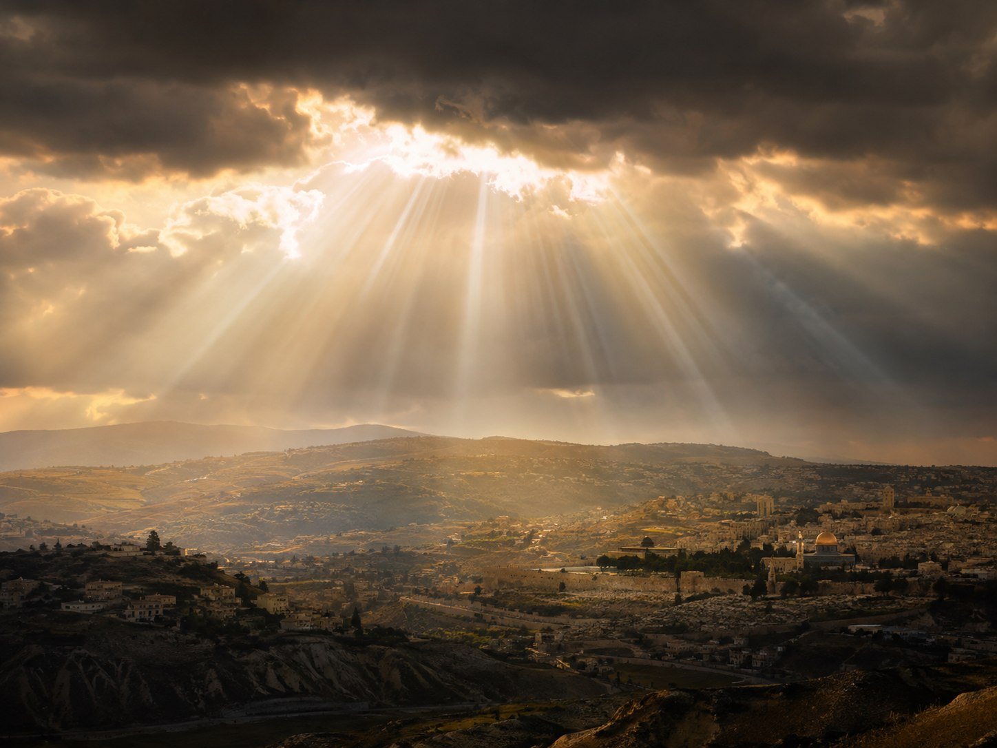 Sunlight breaking through clouds over the ancient city